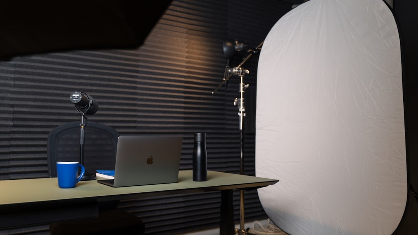 A tidy creative studio workspace with a laptop, lighting, and equipment set up for client work.